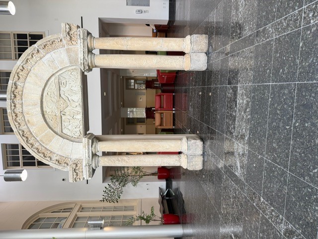 "Stone archway with seating and end tables behind it"