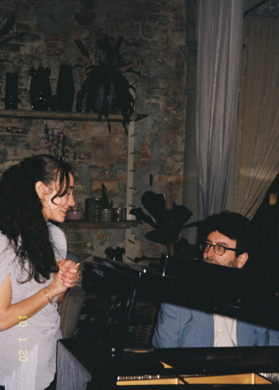 female smiling at man sat at piano