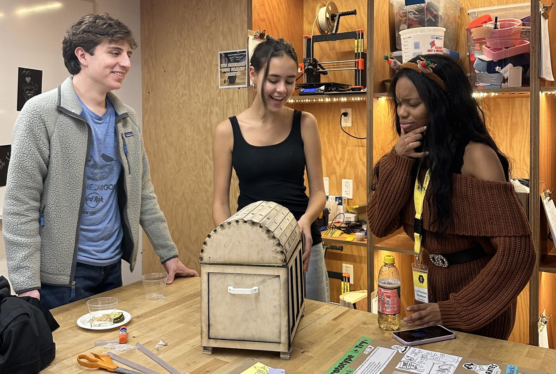 Students discussing a treasure chest project done in Engineering 110: Project and Design 1