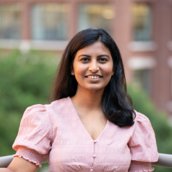 Vibha in a pink blouse standing in front of a building